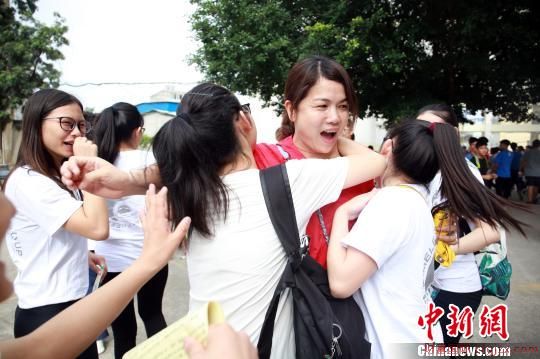 几名考生一起拥向一名穿着红色衣服的教师。　朱柳融　摄