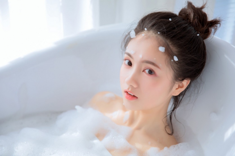泡泡浴丸子头美女面若桃红甜美微笑浴缸湿身美肌写真图片