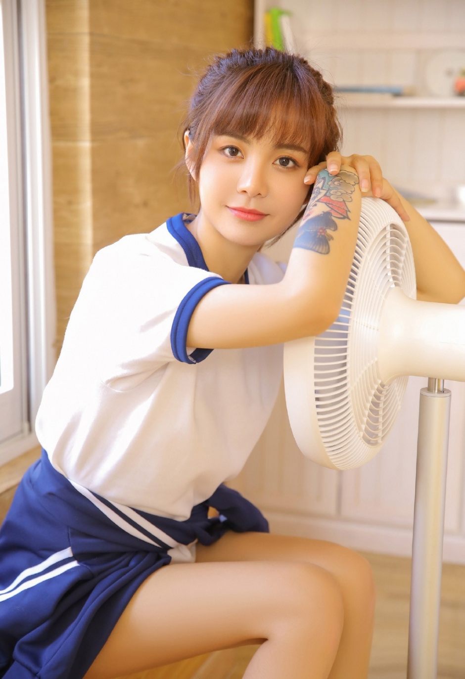 大长腿运动服短裤美女高束马尾辫双手托腮低头浅笑图片