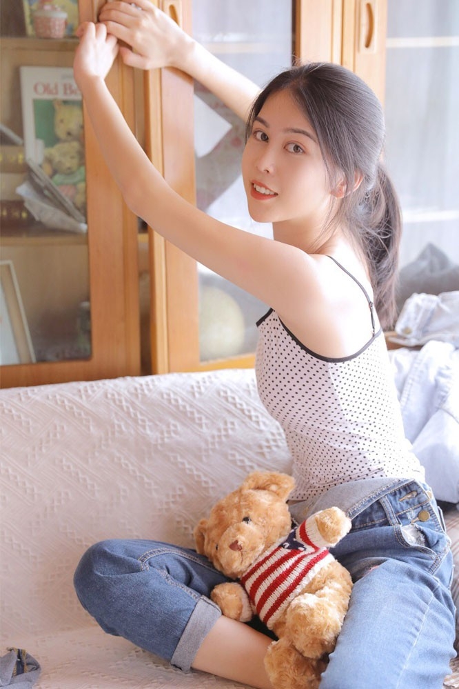沙发白嫩美女高束马尾长相清秀牛仔背带裤苗条身姿图片