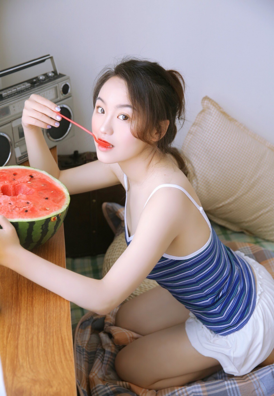 居家美女条纹吊带短裤秀圆润香肩光滑美腿吃西瓜写真图片