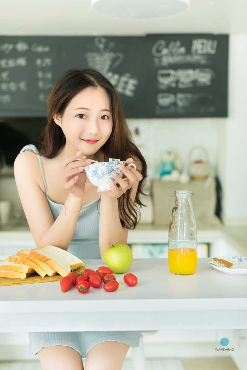 白嫩少女蓝色吊带香肩美腿吃早餐写真图片